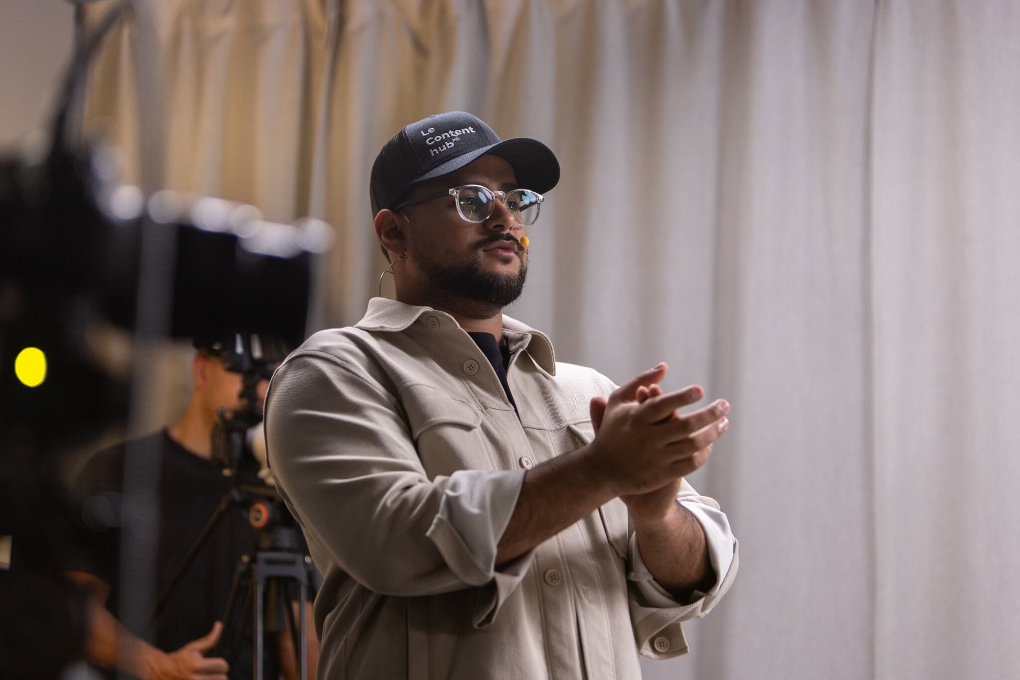Gwen applaudit, casquette Le Content hub, caméraman en arrière-plan