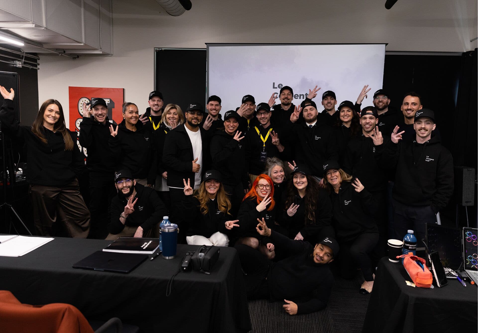 Photo de groupe d'une cohorte en hoodies et casquettes Le Content hub